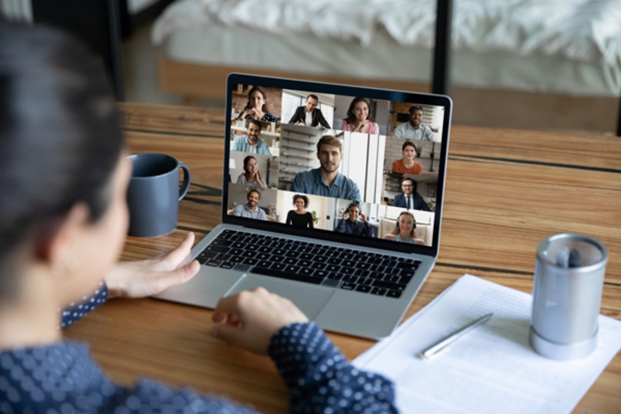 Person deltar i ett digitalt möte via skärmen på sin laptop.