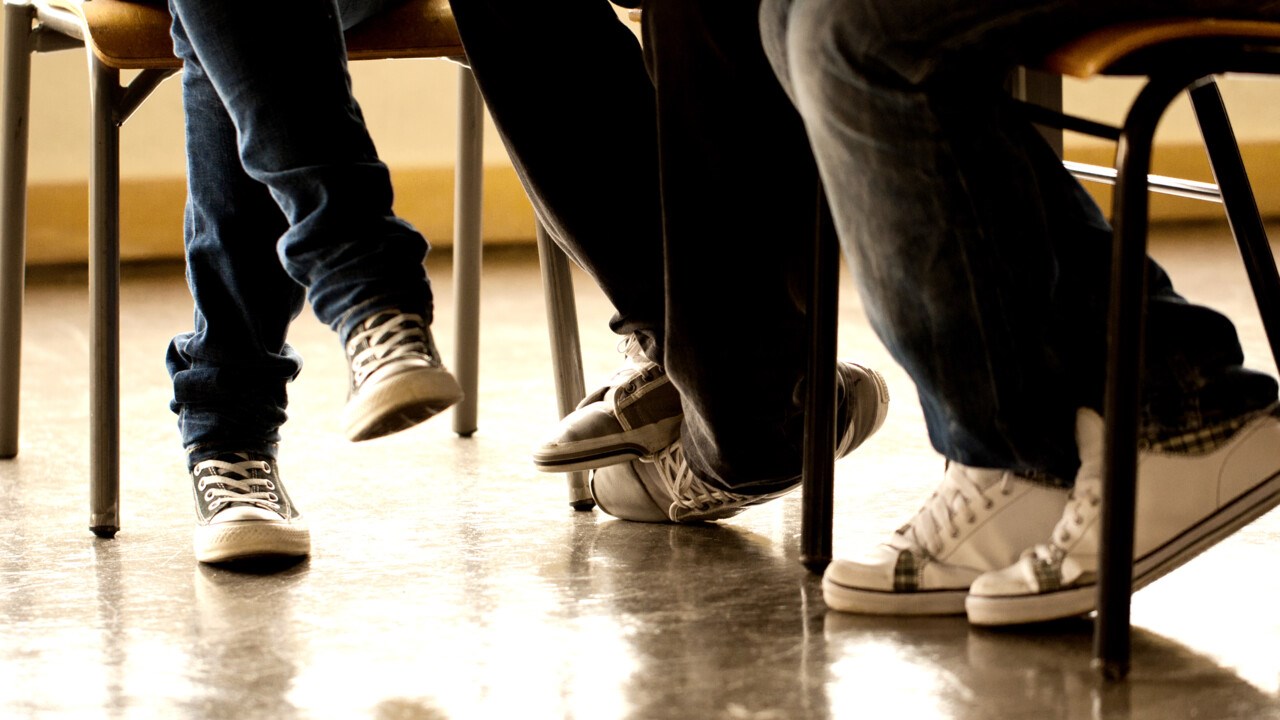 Detalj på ben och fötter på golvet i en skola.