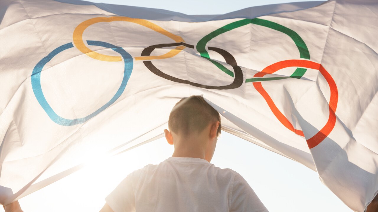 Pojke håller i flaggan för Olympiska spelen.