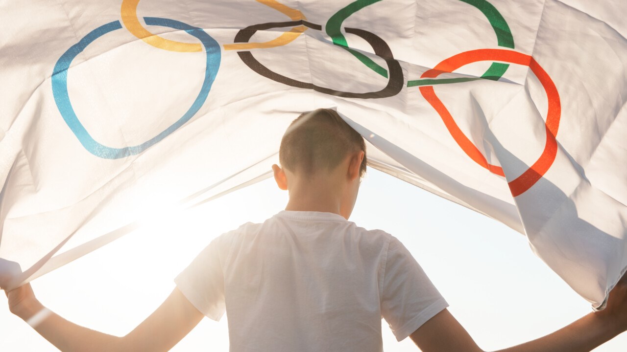 Pojke håller i flaggan för Olympiska spelen.