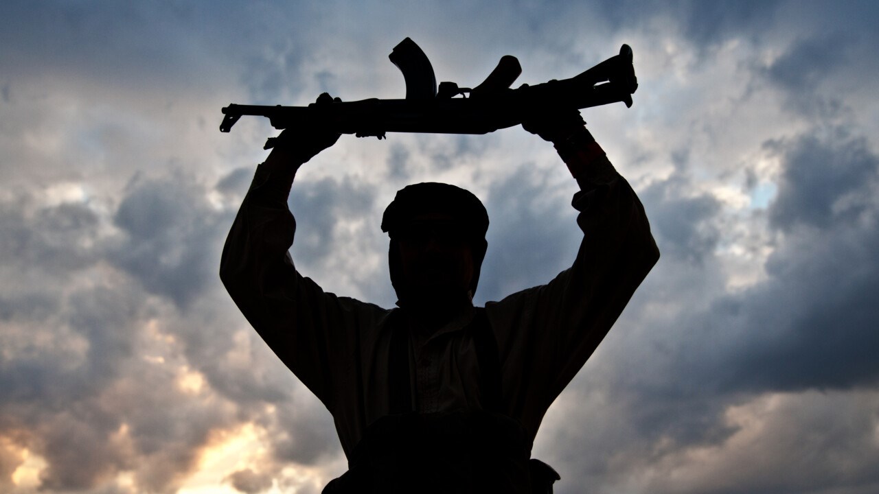 Bild på person i siluett som håller upp ett vapen. 