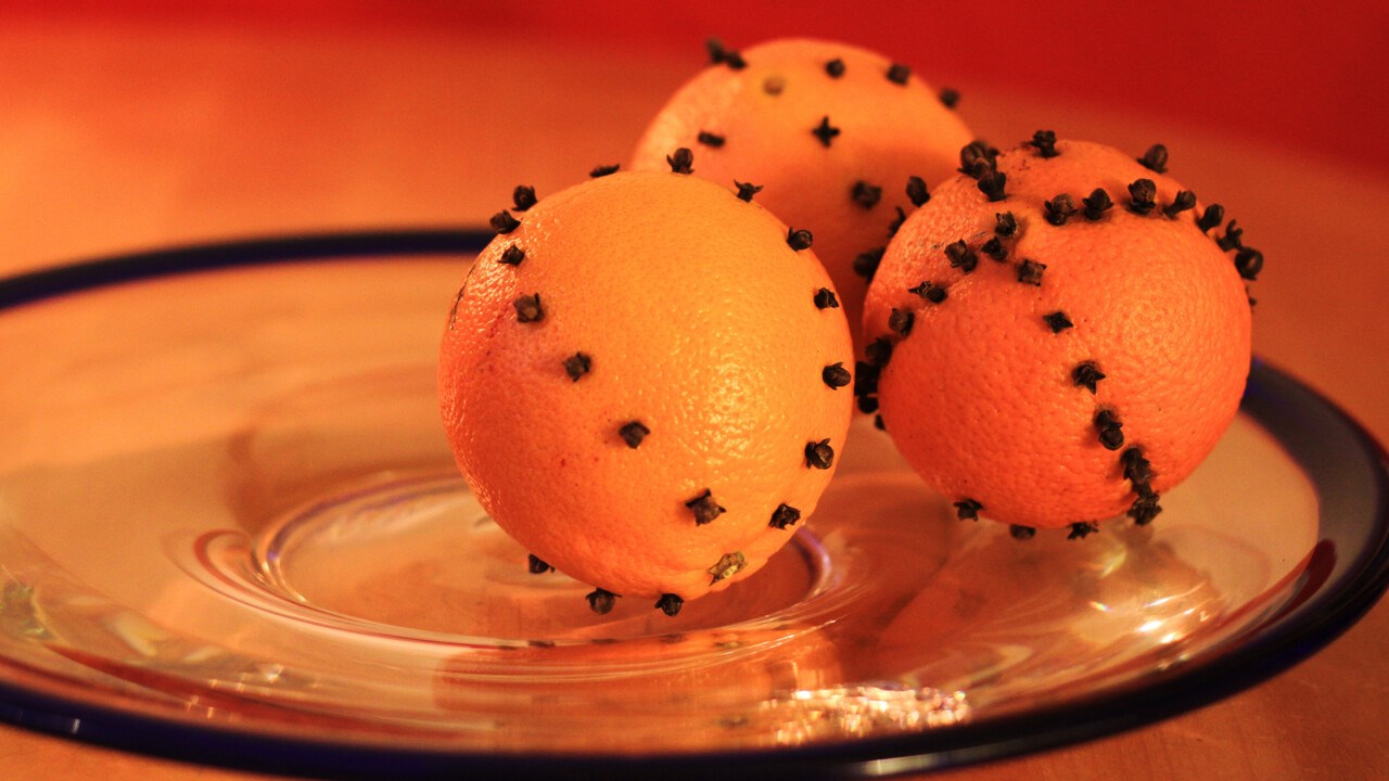 Tre apelsiner dekorerade med kryddnejlikor.