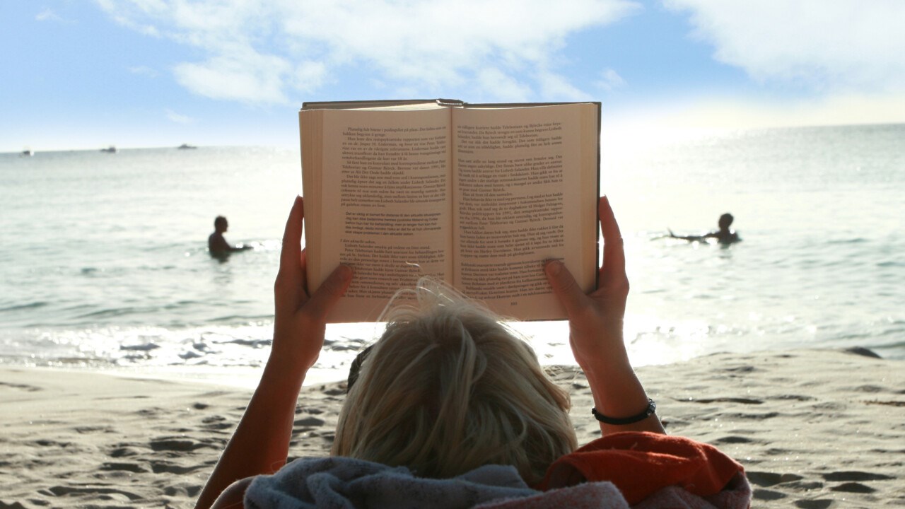 Woman reading book on the beach