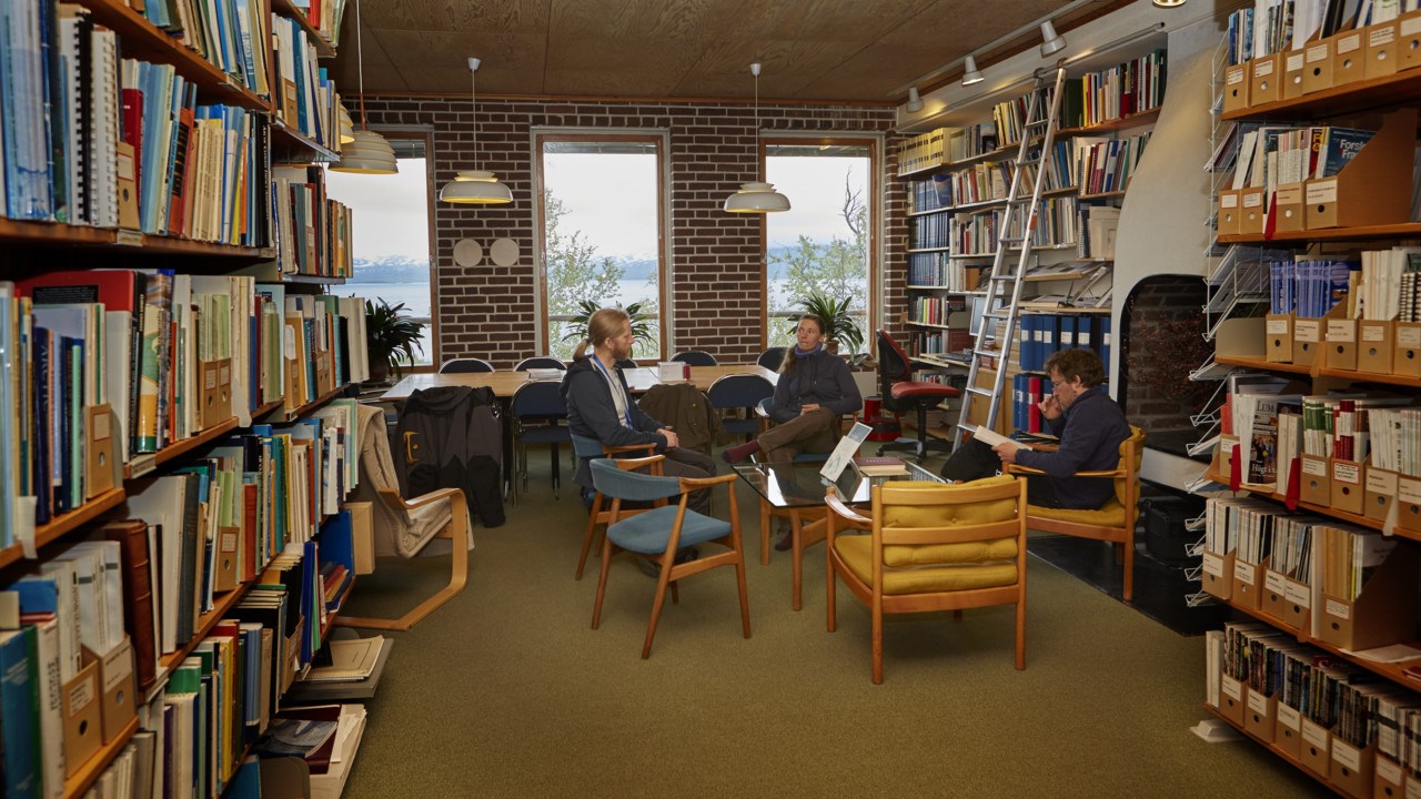 Personer i samtal i biblioteket på Abisko naturvetenskapliga station.