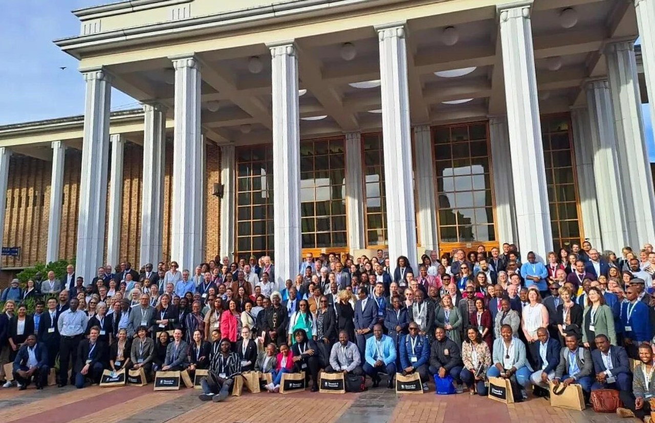 Gruppfoto med hundratals deltagare på SASUF Sustainability Forum. De står framför en stor byggnad med pelare.