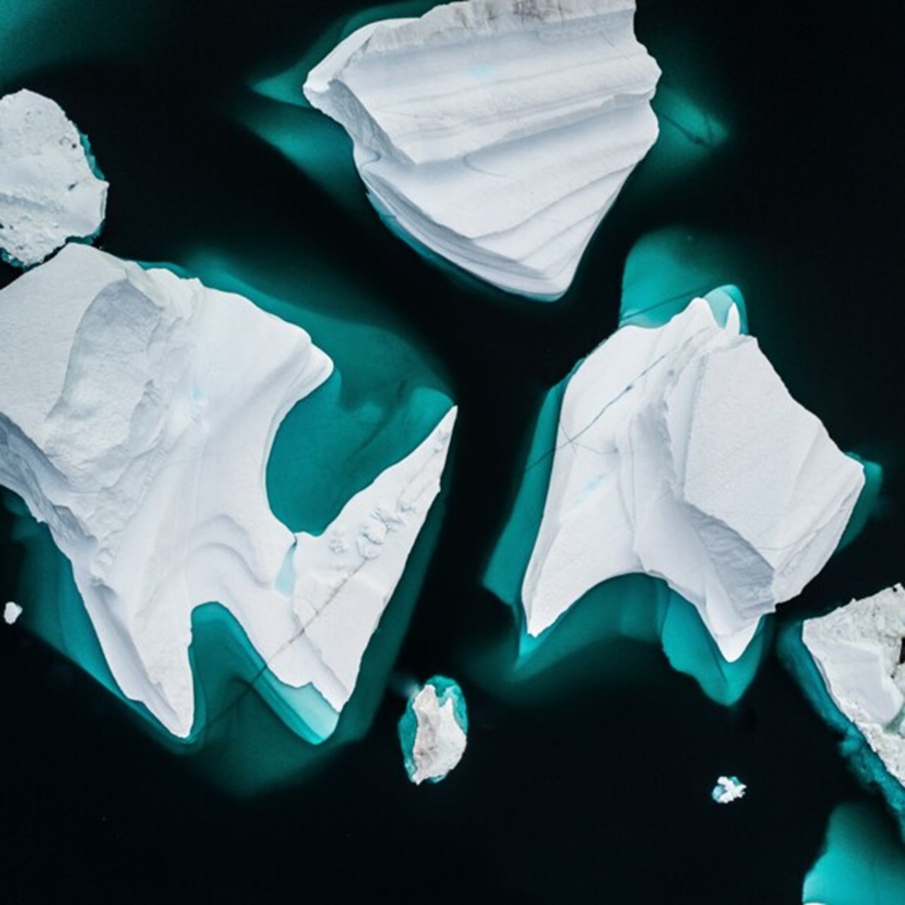 Icebergs from above in dark water