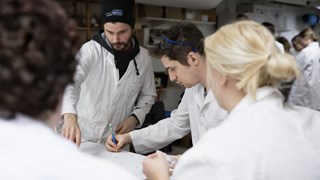 Students of Archaeology doing laboratory work in white lab coats