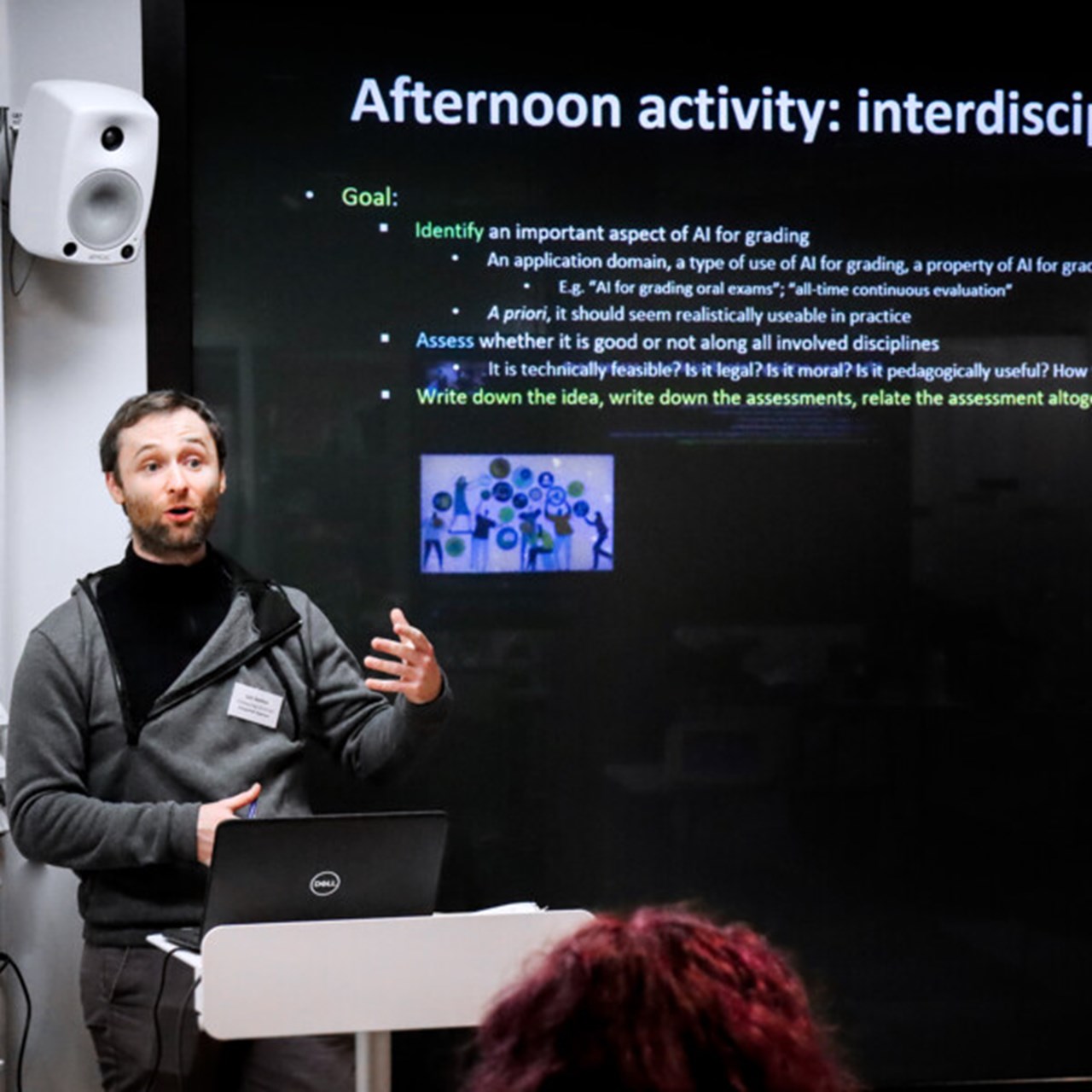 Bilden visar Loïs Vanhée, projektledare för hackatonet, när han föreläser framför en stor bildskärm.