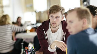 Två studenter pluggar vid ett bord.