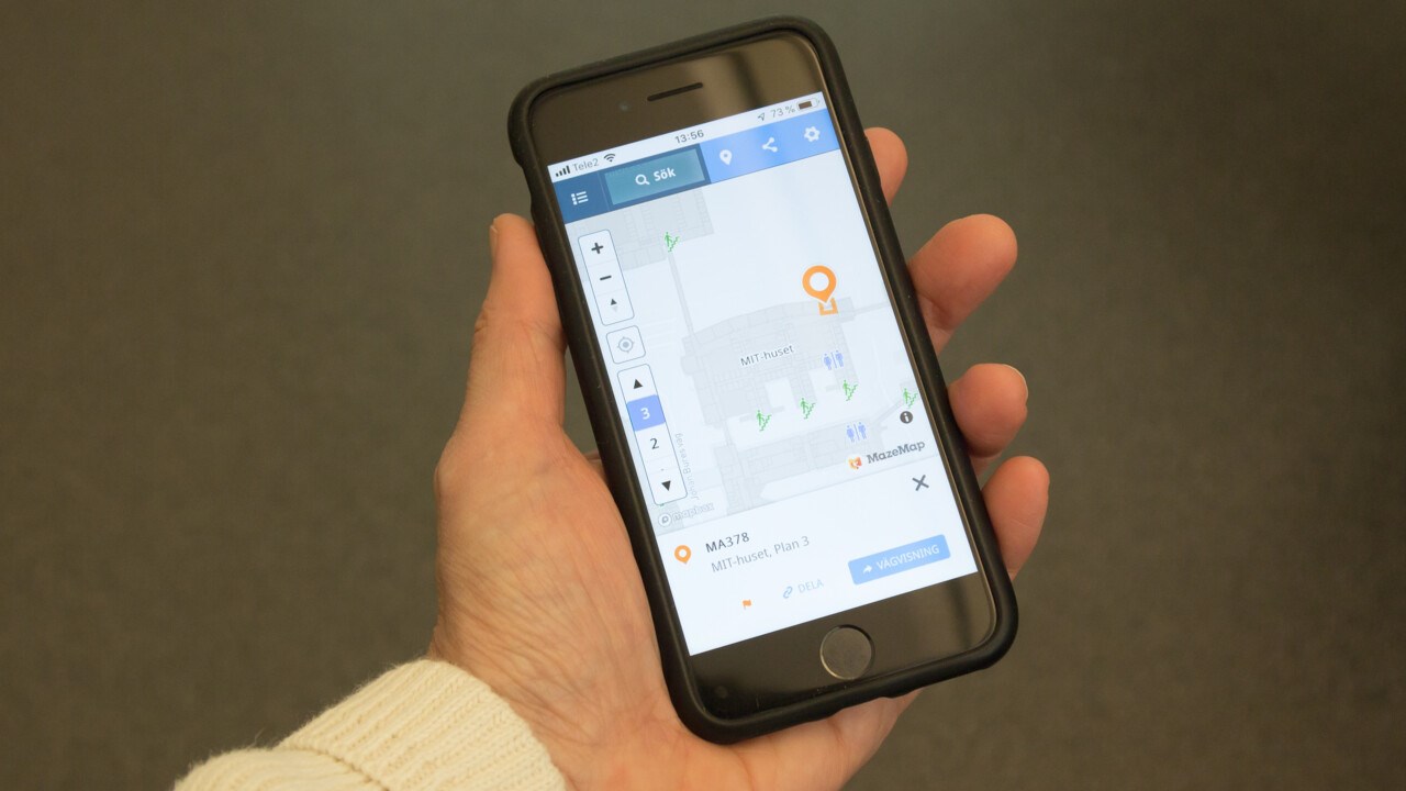 Bild på hand som håller mobiltelefon som visar den digitala kartan över campusområdet.