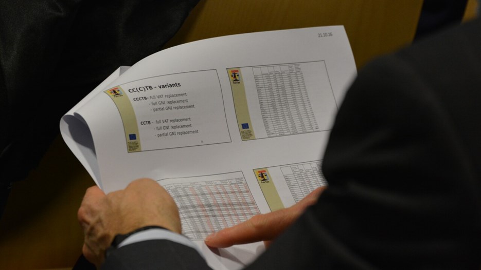 Någon tittar på utskrivna ppt-bilder från FairTax öppna seminarium i Bryssel Okt 2016