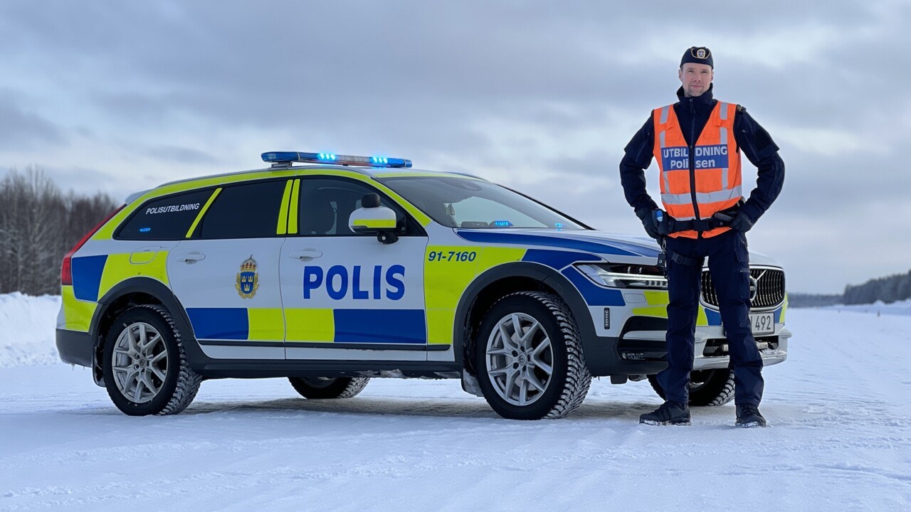 Robin står bredvid en polisbil i vintermiljö.