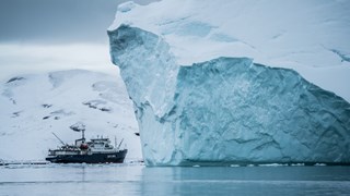 Isbrytare vid isberg i Grönland