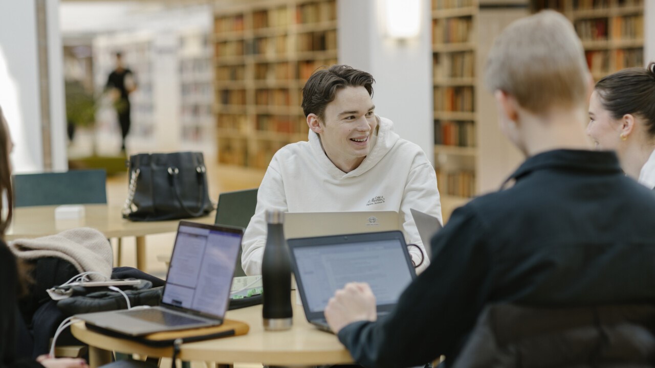 Studenten Hugo pluggar med dator och anteckningsblock.