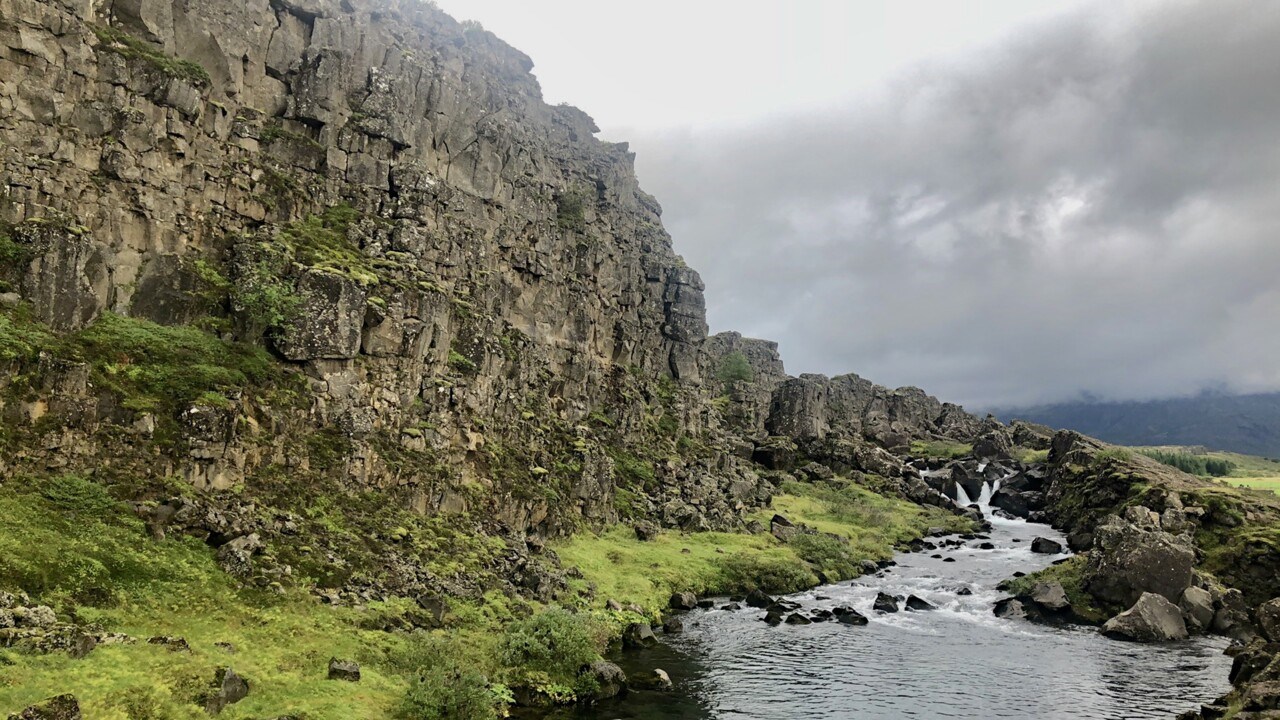 Bild på grönt landskap med berg på Island.