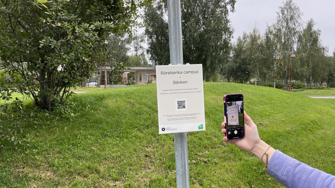 En station i programmet rörelserika campus, mobil skannar QR-kod på skylt.