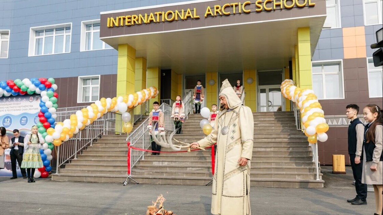 Ceremoni vid invigning av skola. I bakgrunden syns elever i traditionella kläder.