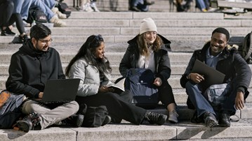 Image of international students by the campus pond 