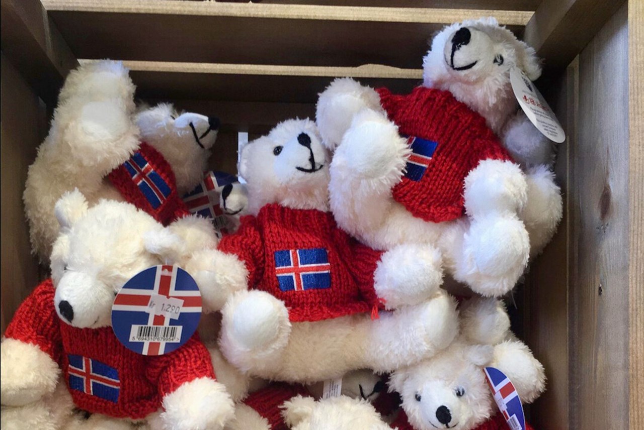 Vita nallebjörnar i en trälåda med isländska tröjor och prislapp