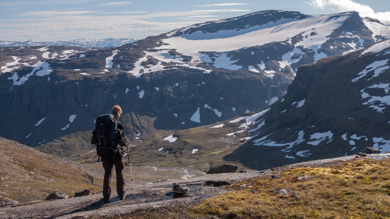 Person med ryggsäck som vandrar i fjällen.