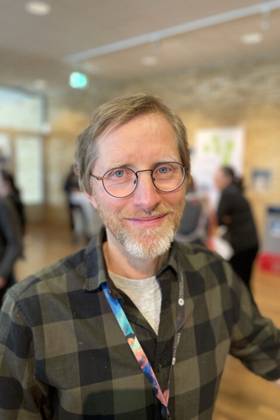Man med vitt skägg och rutig skjorta.