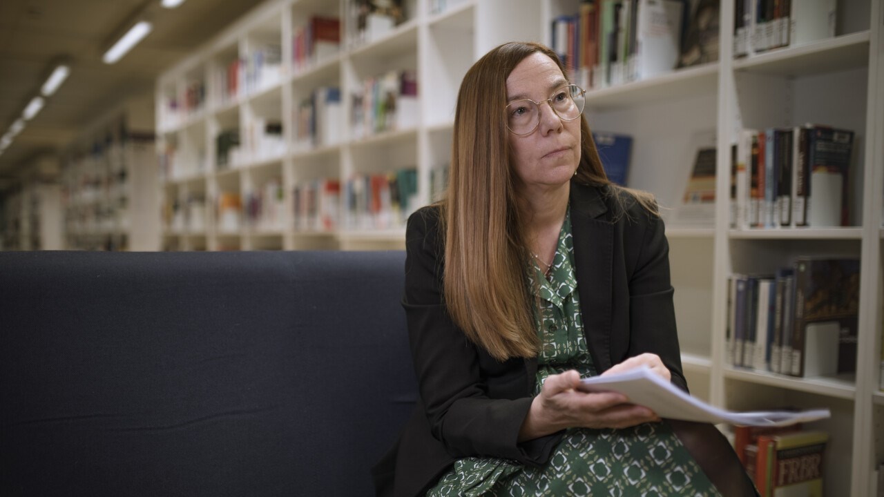 Britt-Inger Keisu sitter på en stol i biblioteket.