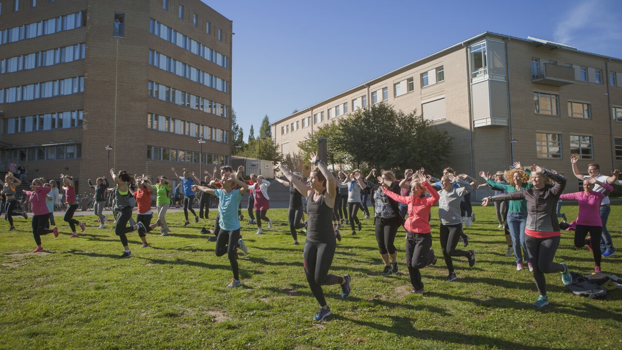 Personer grupptränar utomhus.