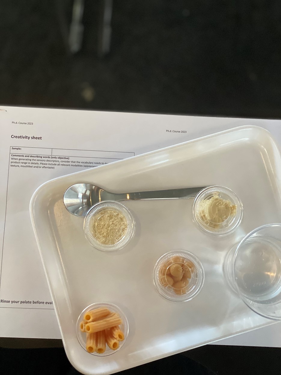 A tray with chickpeas and pasta i small sample containers.