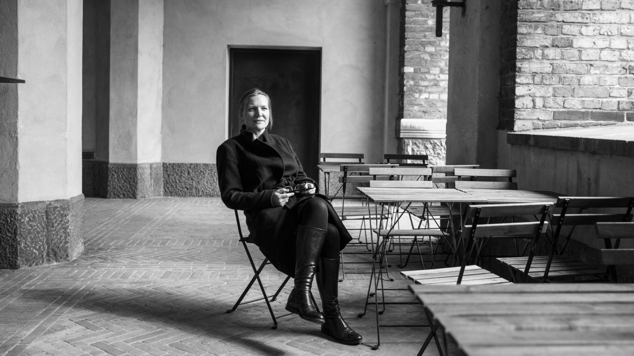 Foto på professor Mette Buchardt sittandes vid ett bord på en altan.