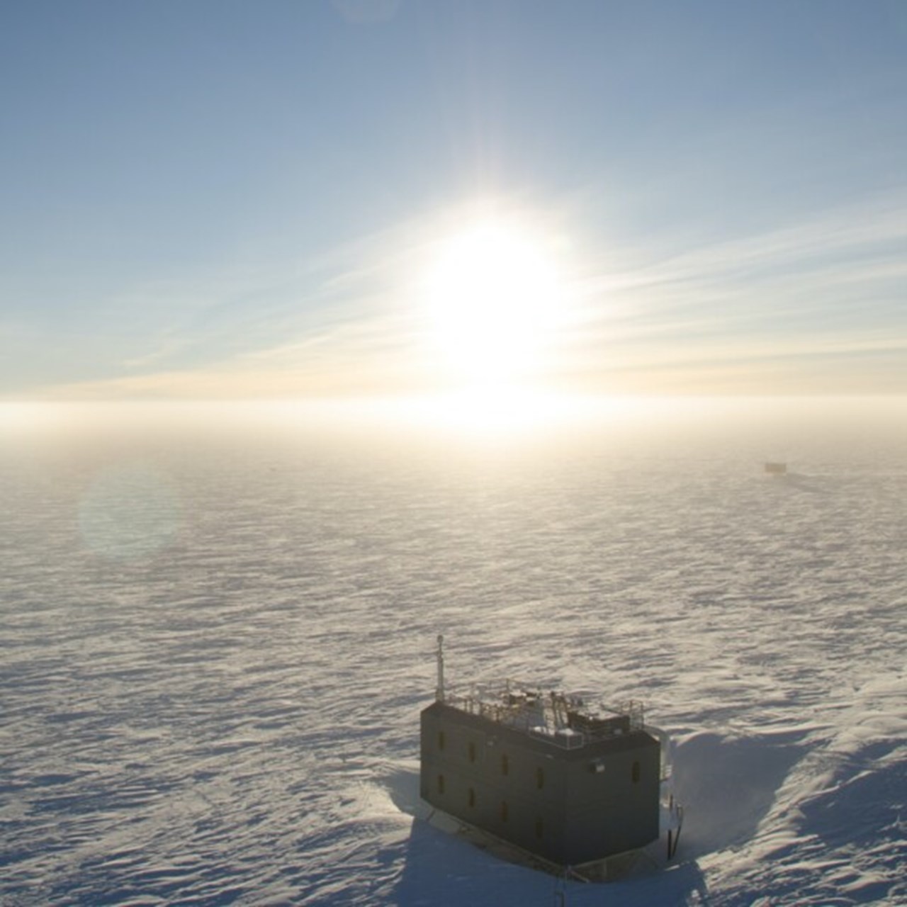 Solen har stigit några grader över horisonten vid en atmosfärisk forskningsobservatorium på sydpolen, Antarktis