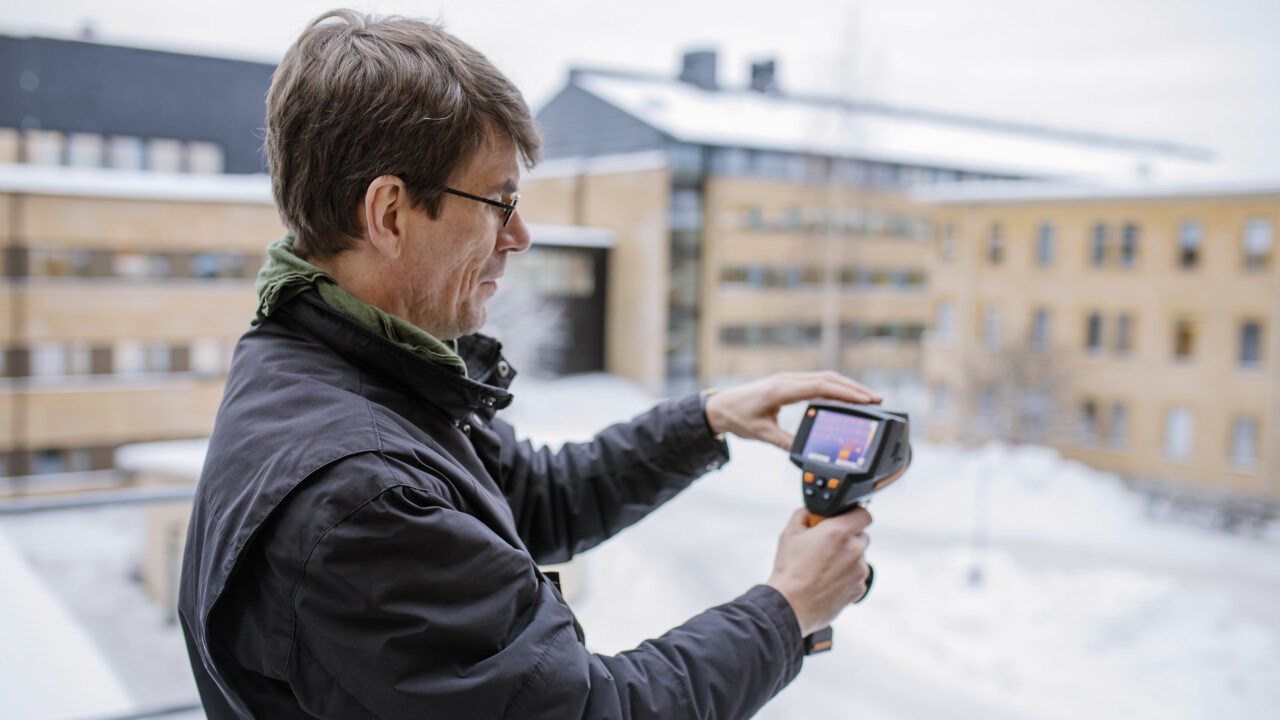 Thomas Olofsson, professor of energy efficiency with a focus on development, at the Department of Applied Physics and Electronics holding a gimmic over a snow covered scenery