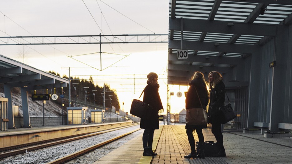 Three persons  on a trainstation