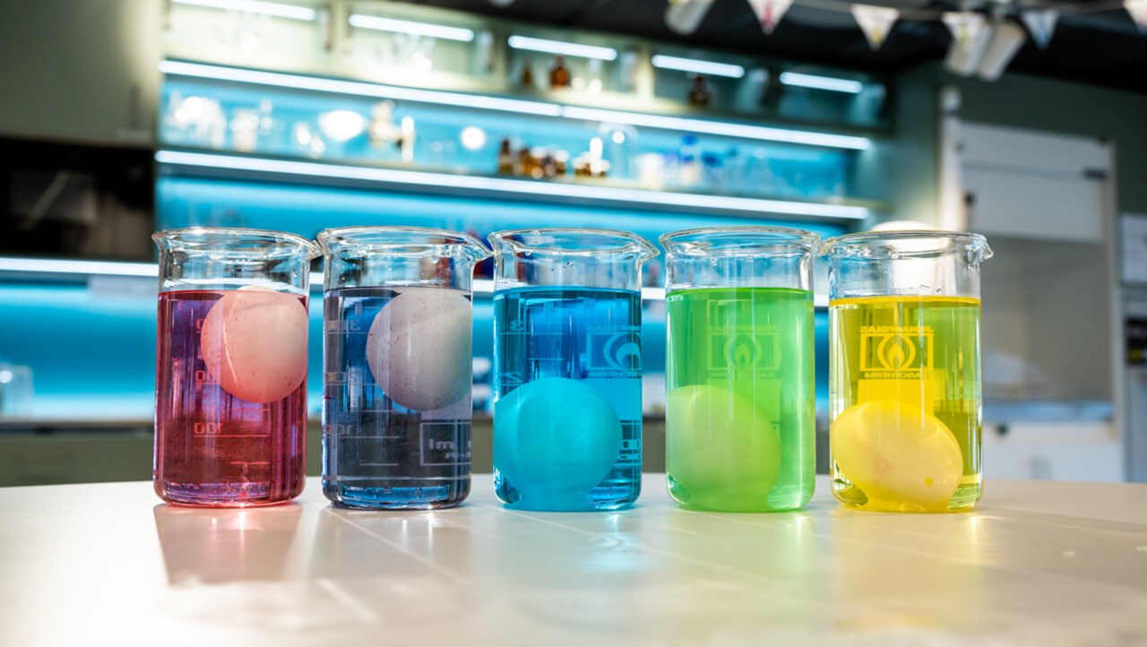 Ägg i glas med vätska i olika färger