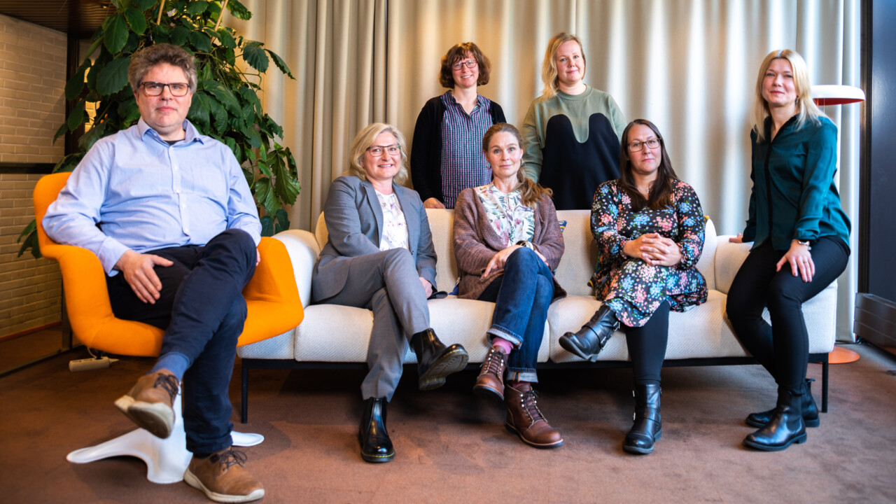 Photograph of a group of people sitting on a sofa