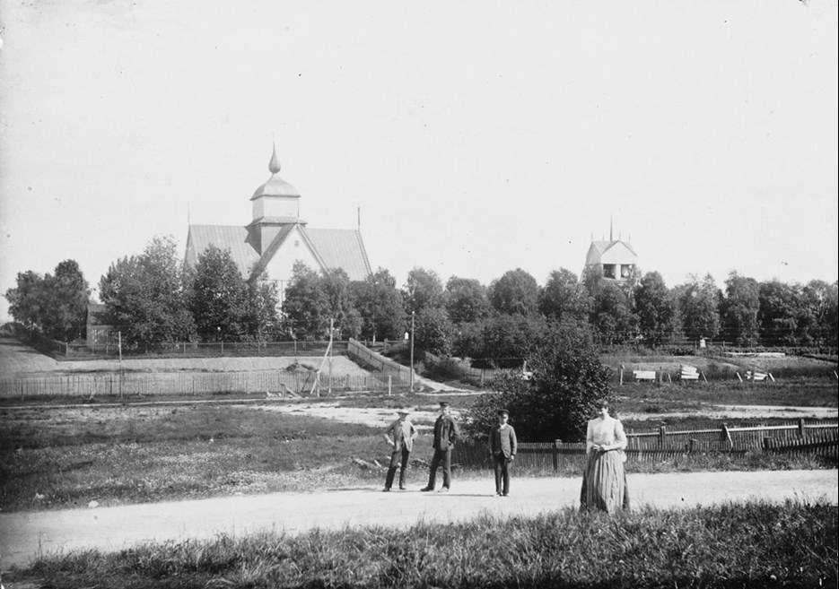 Svartvitt foto på fyra personer utanför Piteå stadskyrka 1906