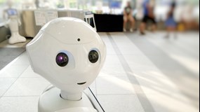 A robot looking into the camera with big eyes.
