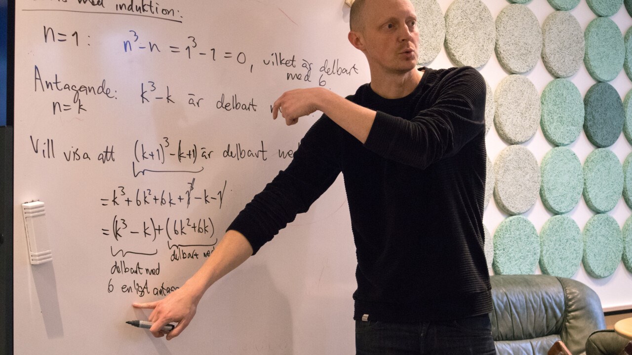 Bild på Lars-Daniel Öhman, lektor i matematik, vid whiteboardtavla.