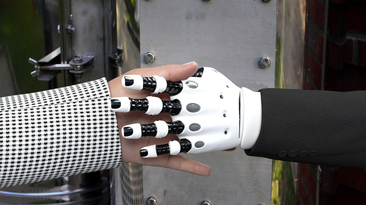 Närbild på robothand skakar hand med en människa.