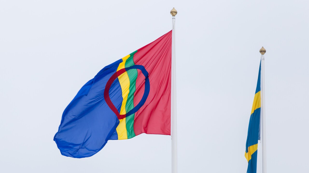Samisk flagga vajar bredvid svensk flagga som sloknat.