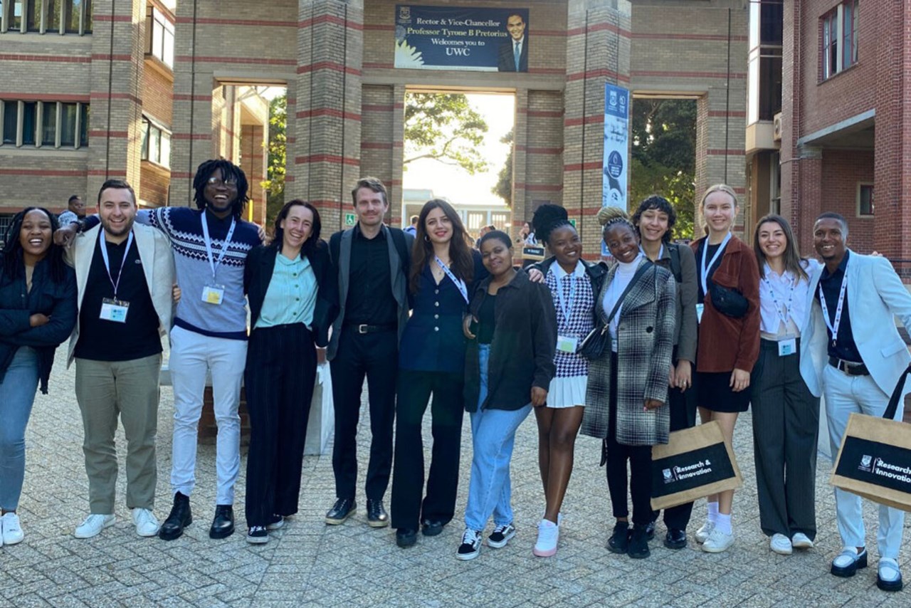 Swedish and South African students in the SASUF student network standing in front of the entrance to University of Western Cape.