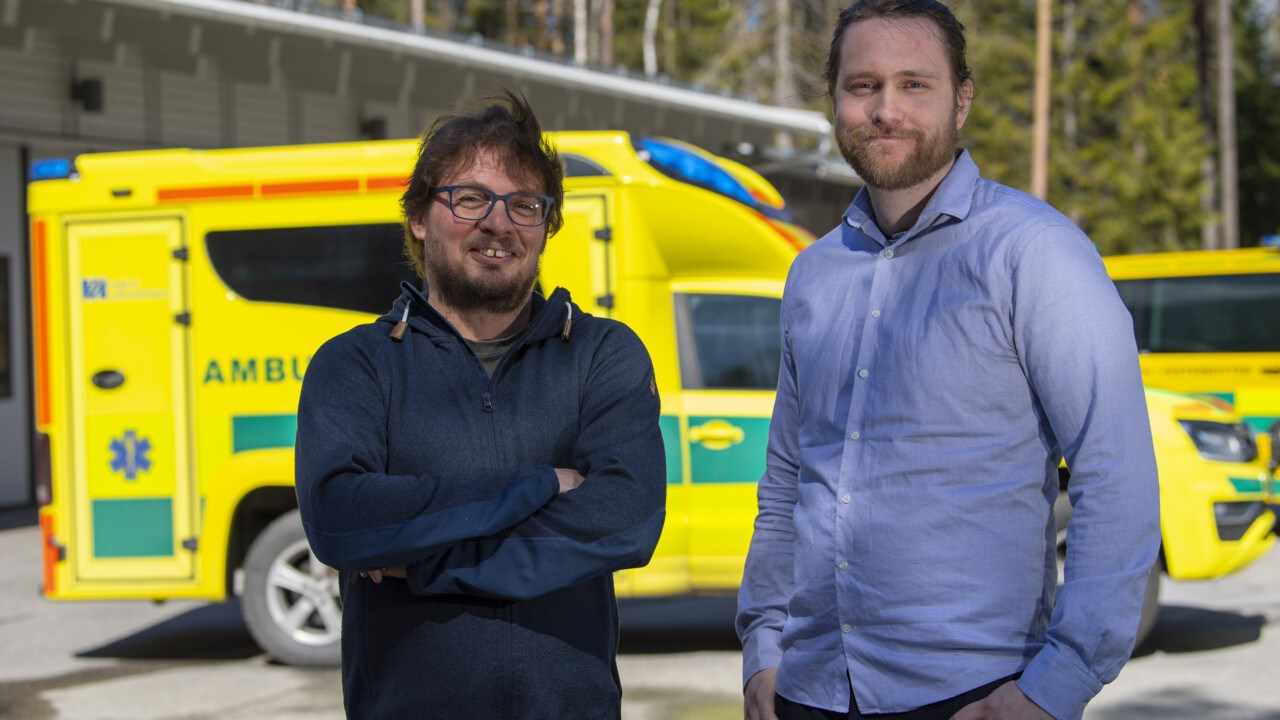 Patik Rydén, universitetslektor och biträdande prefekt vid Institutionen för matematik och matematisk statistik, står framför en ambulans tillsammans med Anton Vernersson