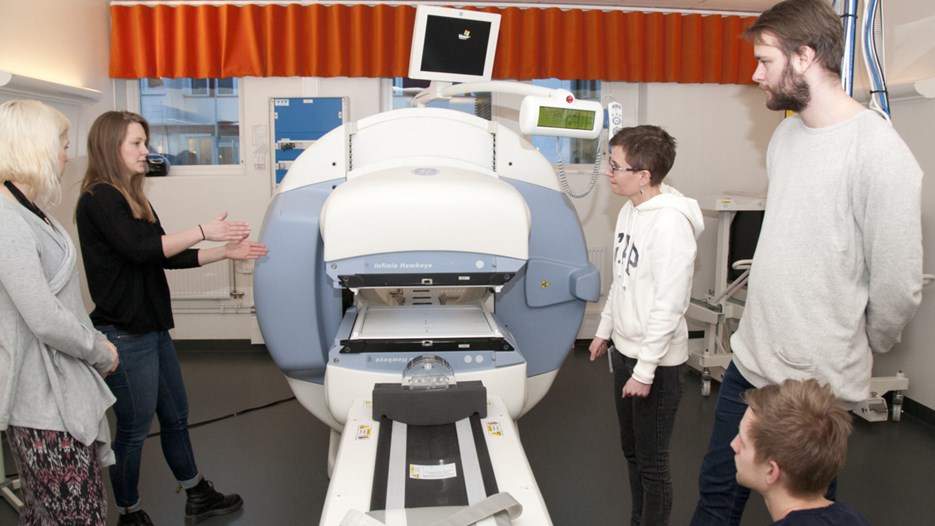 Bild på studenter och lärare vid en PET-kamera