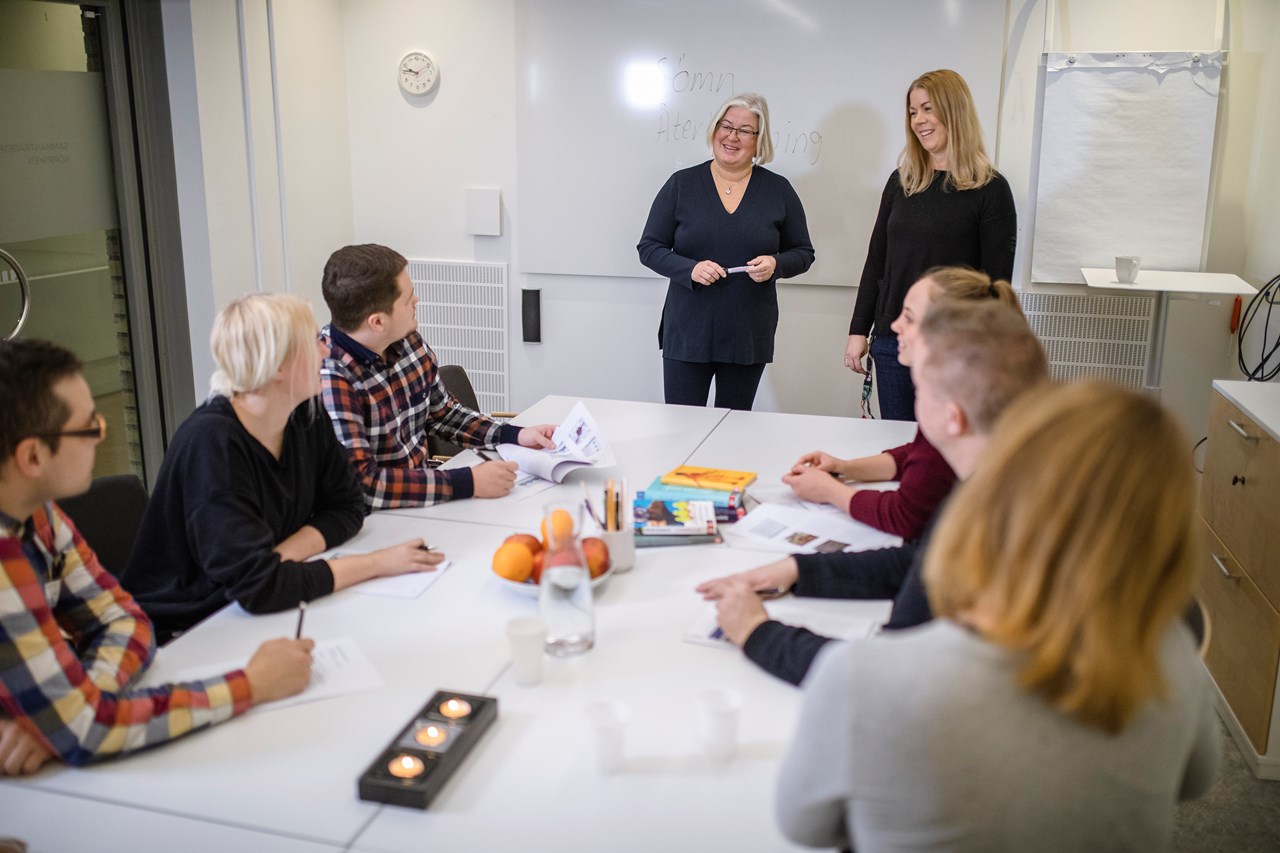 Bild på Studenthälsan som håller i en grupp för några studenter som sitter vid ett bord.