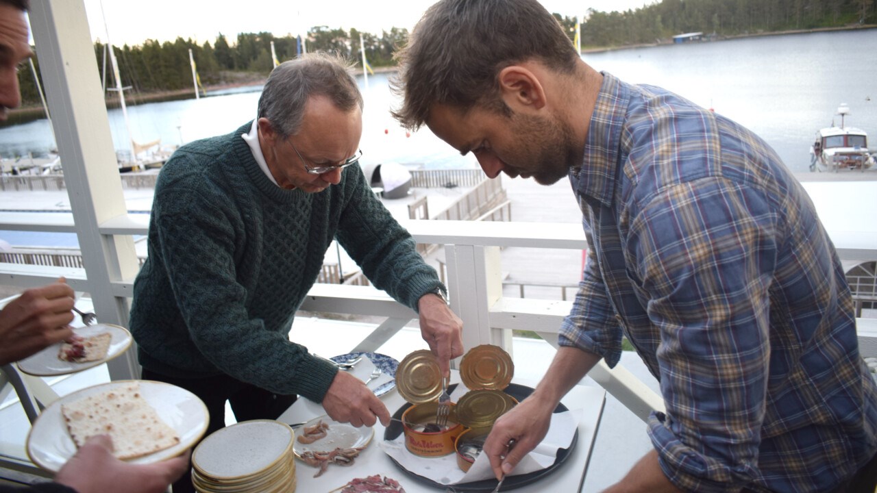 Runar Brännlund opens a can of sour herring at the Ulvön Environmental Economics Conference.