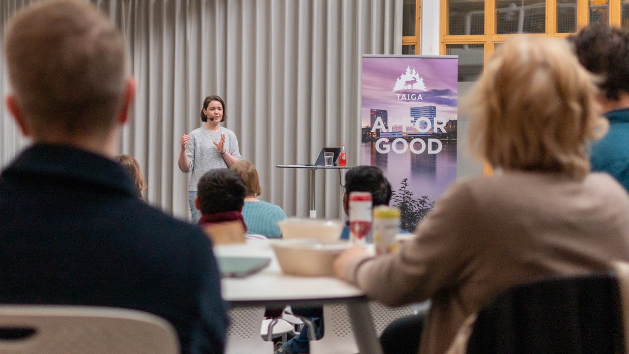 Bild på när Erika Olsson, projektkoordinator för World Childhood Foundations AI-satsning Stella Polaris presenterar inför forskare och representanter från näringslivet i MIT-place.