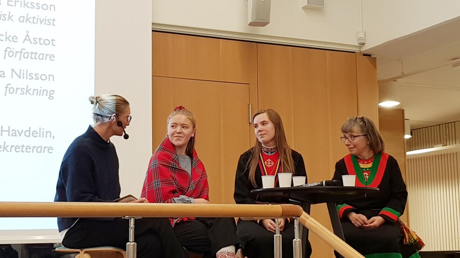 Four women seated in a panel discussion, with three clad in Sami clothes
