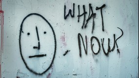 Graffitti på en vägg med texten What now?
