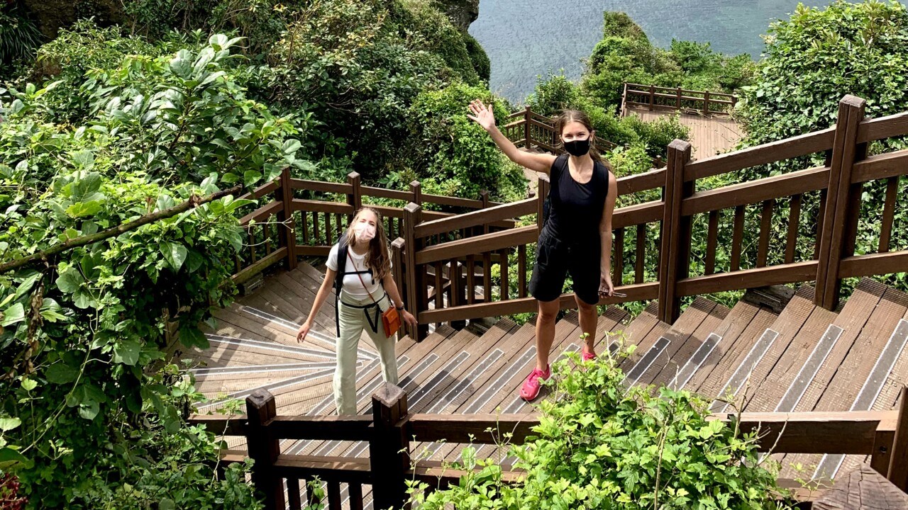 Foto med Signe och Anja ståendes på en trappa med utsikt över Seoul i bakgrunden.