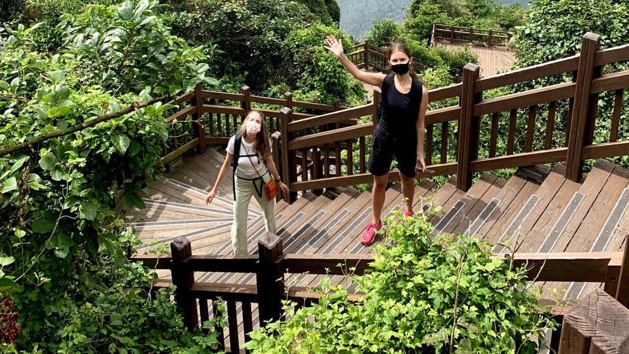 Foto med Signe och Anja ståendes på en trappa med utsikt över Seoul i bakgrunden.