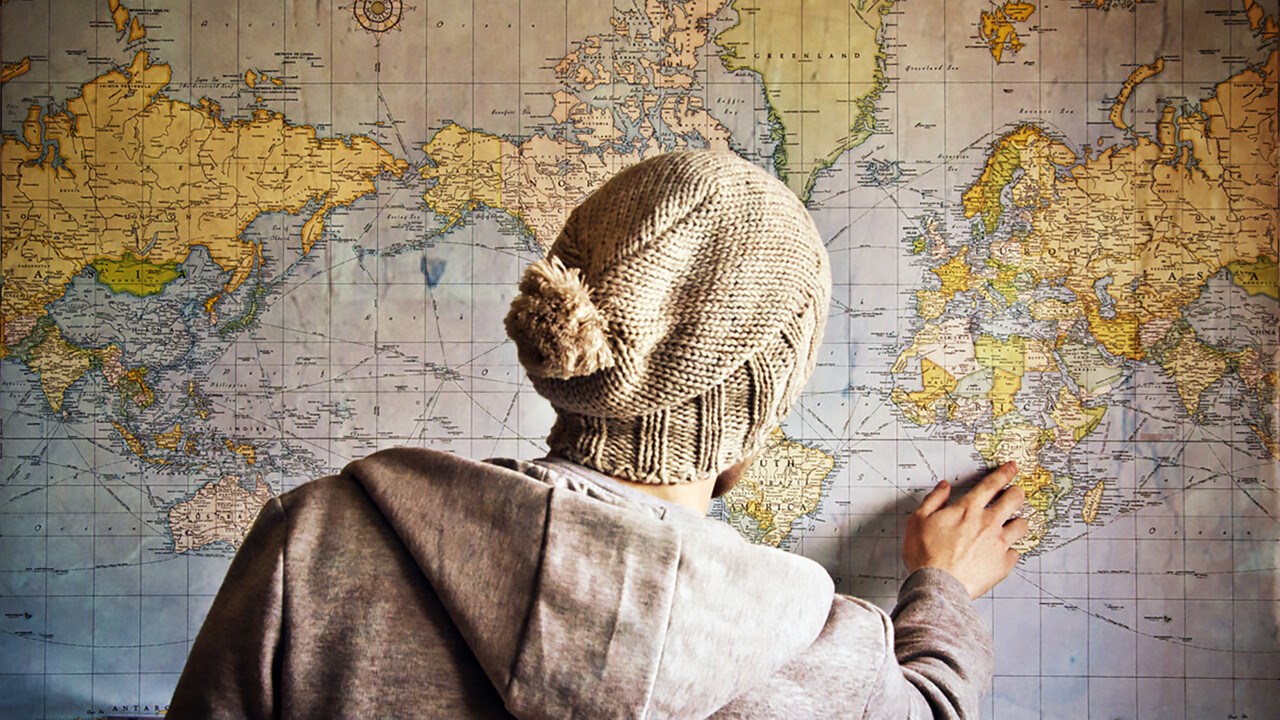 Photo of a person in front of a world map.